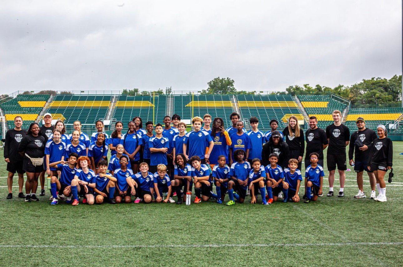 RCSL players and coaches posing together on a stadium field