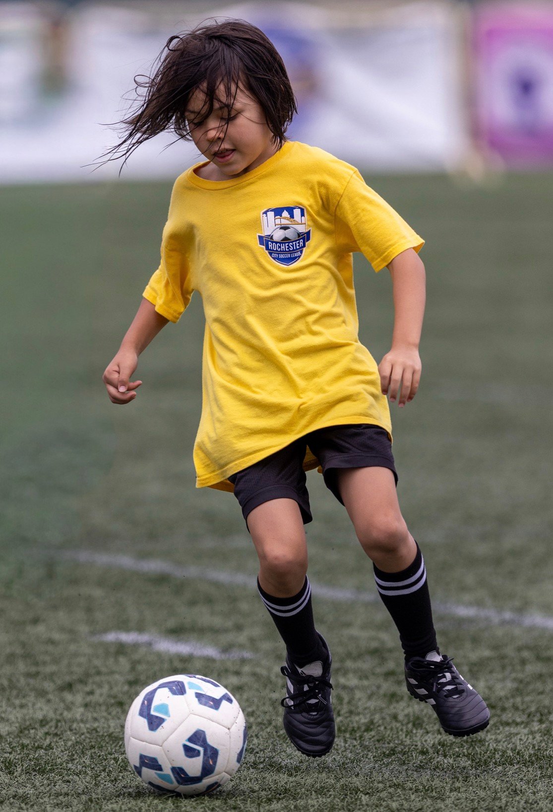 A young RCSL player dribbling a soccer ball