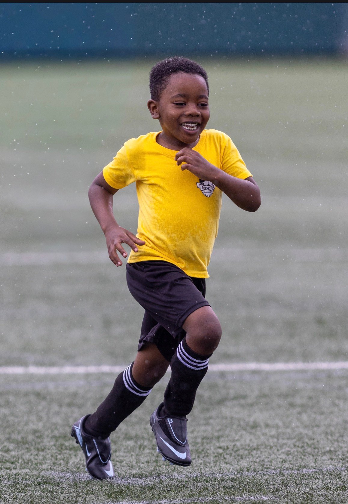 A smiling RCSL player running on the field